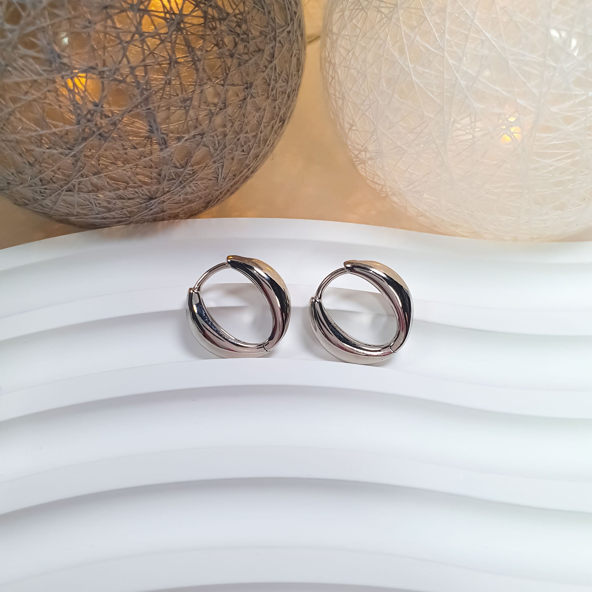 Kompaktie ovālie auskari ar spožu metāla virsmu