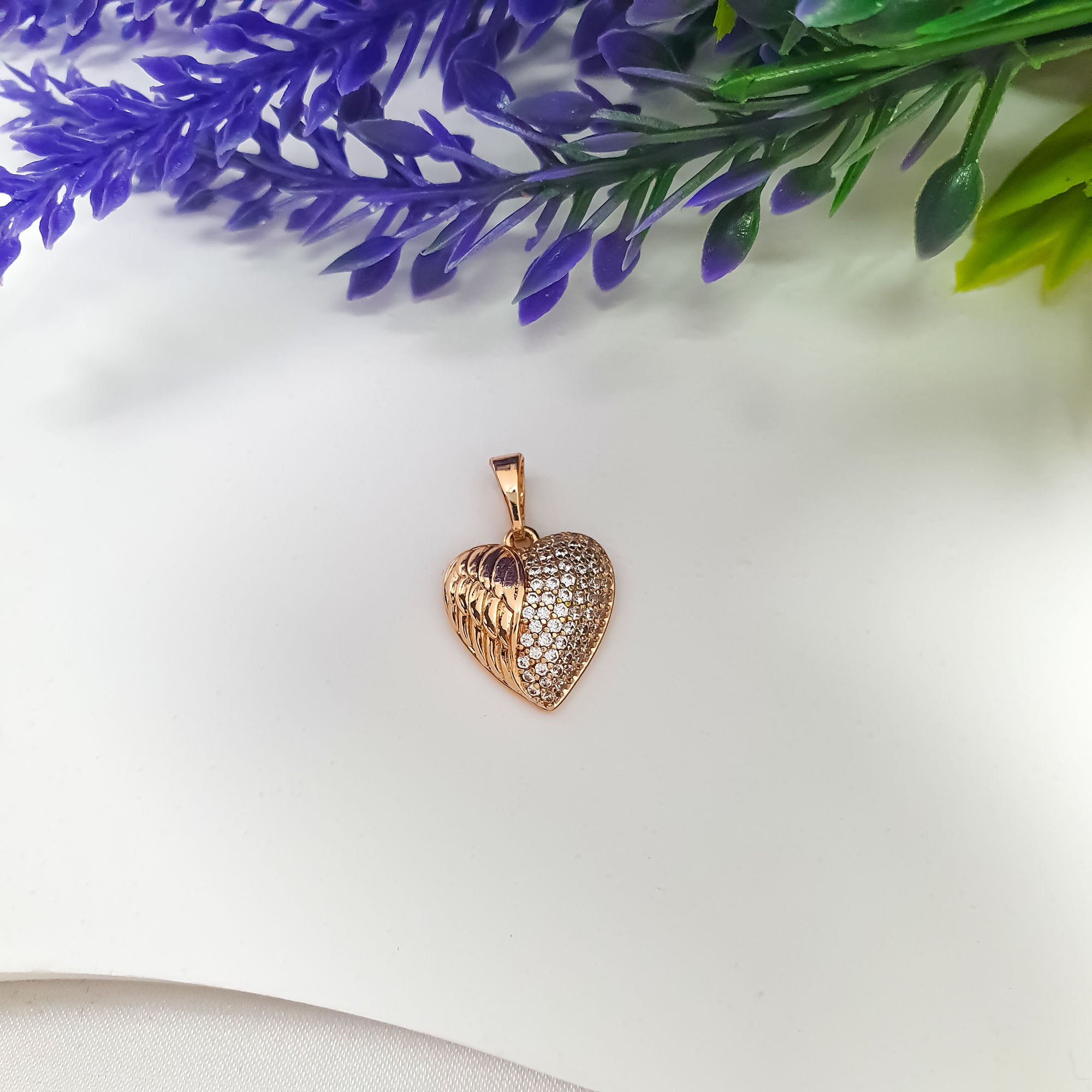 Zelta krāsas kulons: spārna motīvs un cirkonu klājums